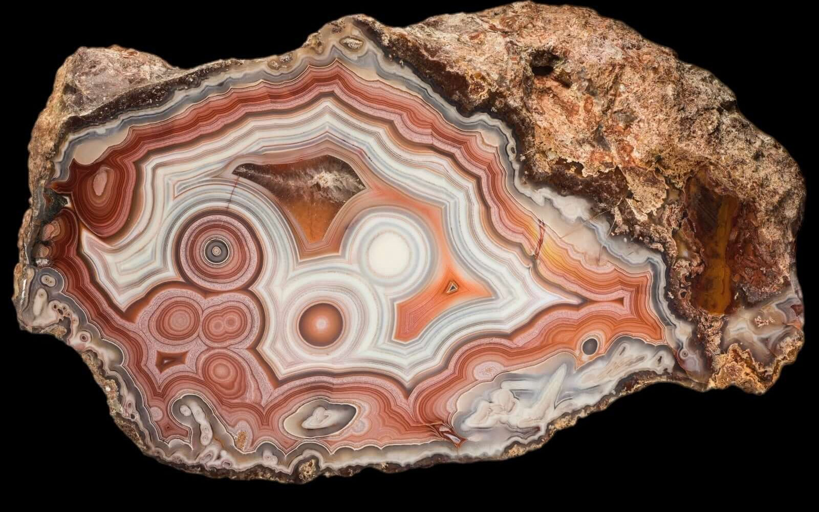 Close-up of THE HEART OF CHIHUAHUA a colorful agate stone with concentric patterns on a black background