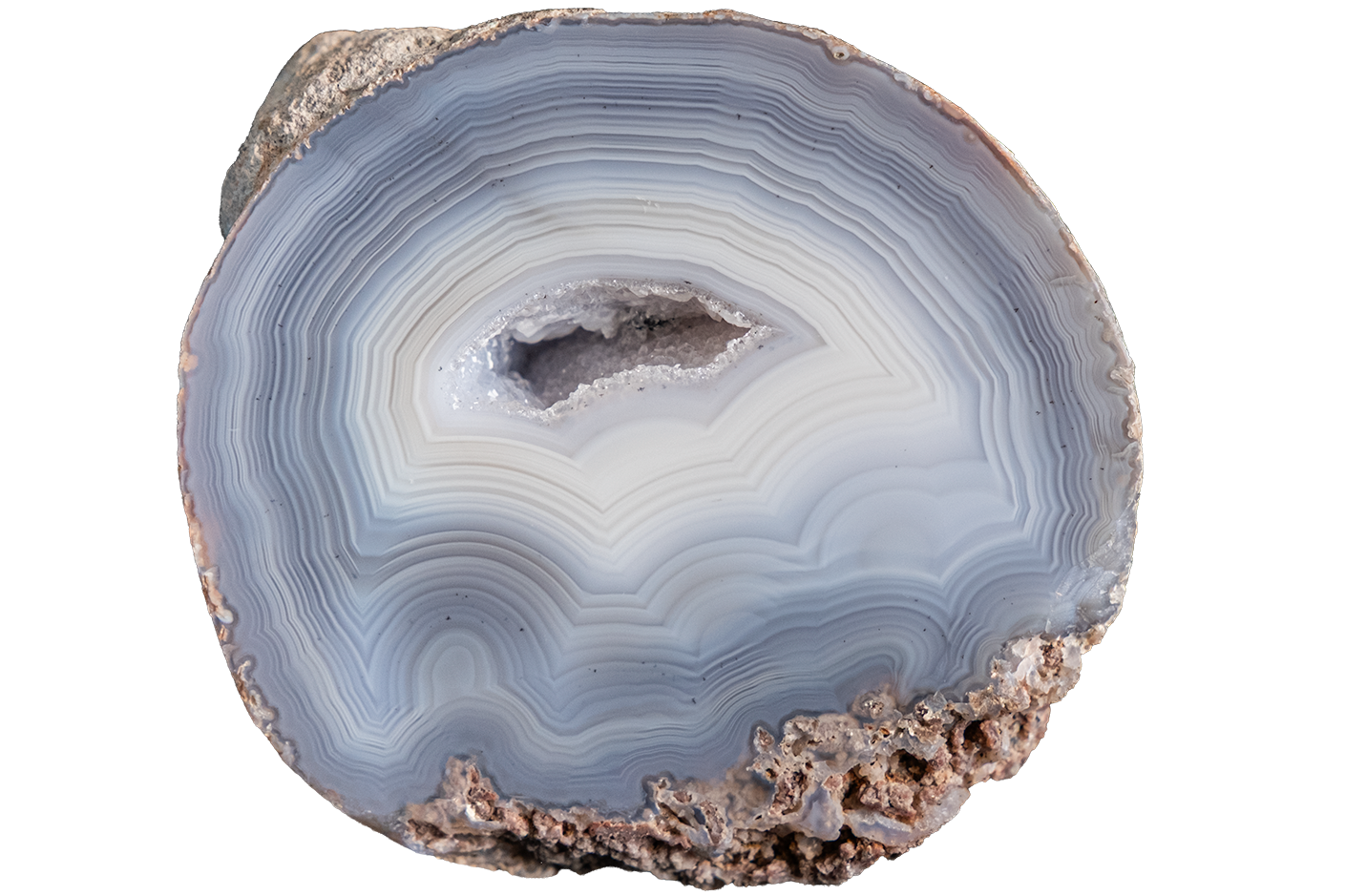 A polished cross-section of a banded agate geode showing concentric layers of light blue, gray, and white, with a rough brown matrix border, isolated on a white background.