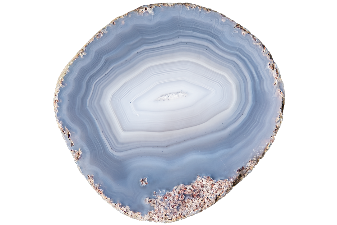 A polished slice of agate or jasper stone with concentric bands of pale blue, white, and gray, set against a plain white background.